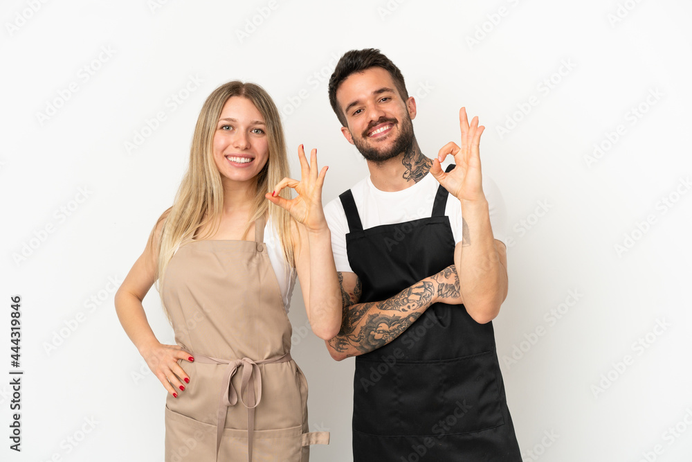 Restaurant waiter over isolated white background showing an ok sign with fingers Restaurant waiter over isolated white background showing an ok sign with fingers