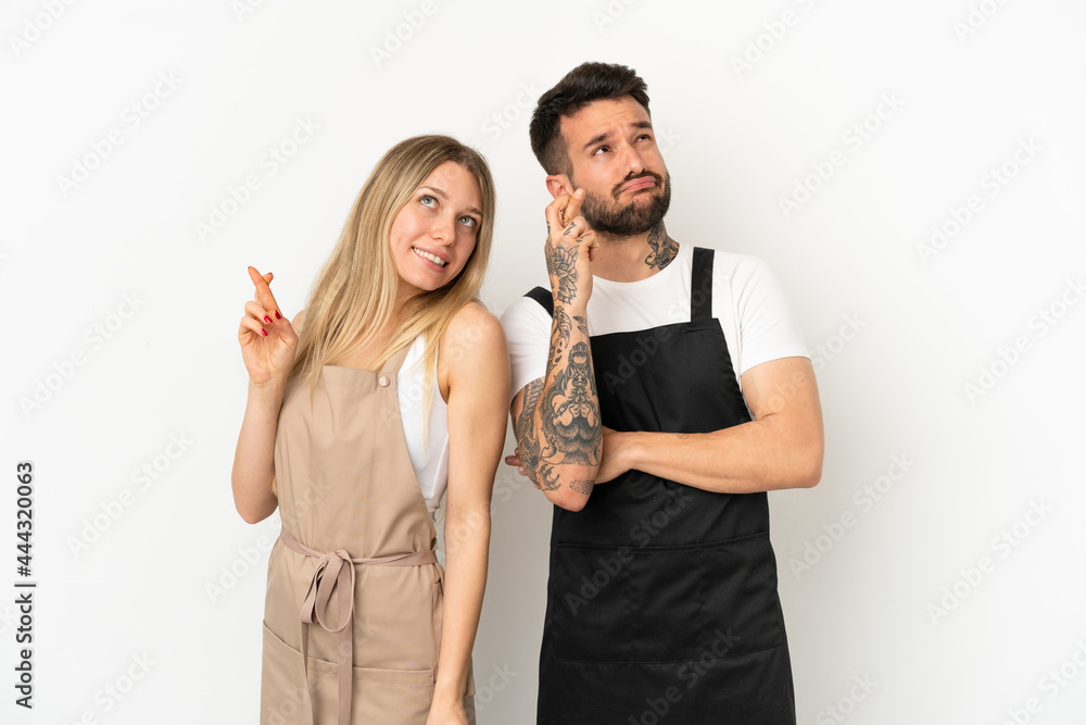 Restaurant waiter over isolated white background with fingers crossing and wishing the best Restaurant waiter over isolated white background with fingers crossing and wishing the best