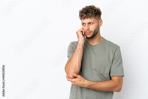 Young caucasian handsome man isolated on white background with tired and bored expression © luismolinero