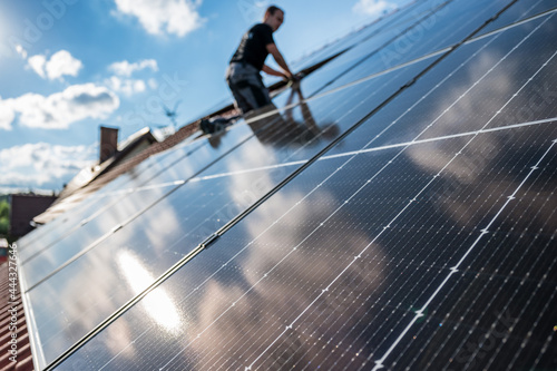 Obraz na płótnie Photovoltaic panels on the roof and intaller in the background w salonie