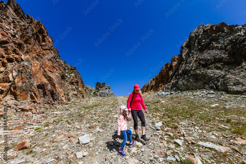Fototapeta premium Happy hiker woman and girl at mountains lake
