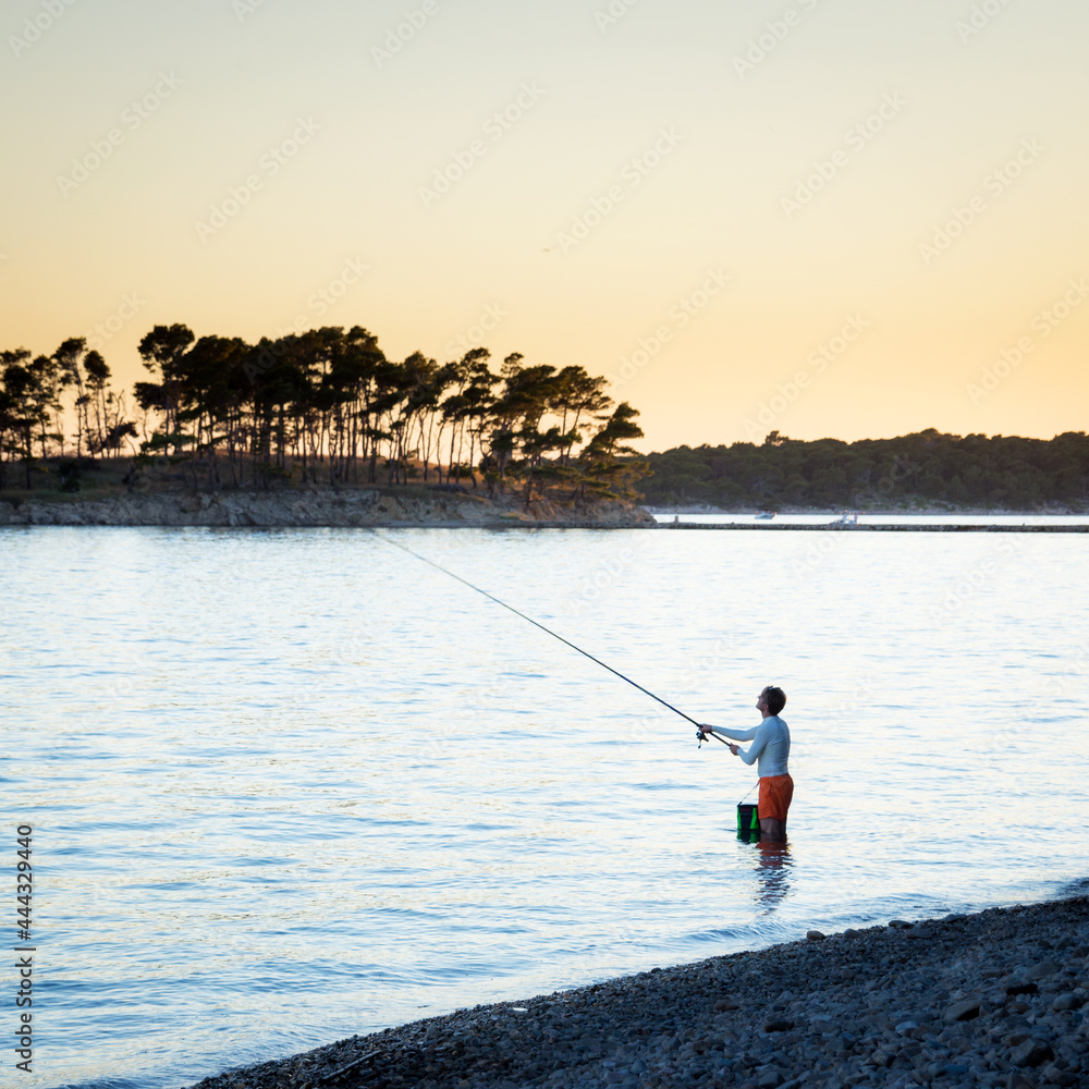 Man fishing on the shore of adriatic sea on island rab