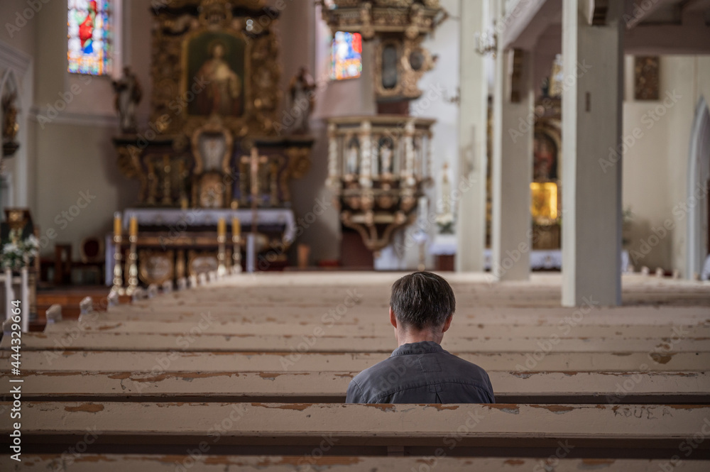 One man siting in the empty catholic church One man siting in the empty catholic church