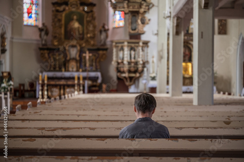 One man siting in the empty catholic church © Dziurek