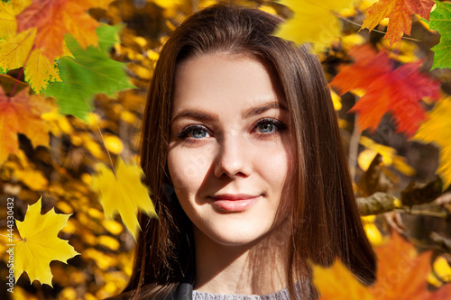 Young woman posing on the autumn park background.