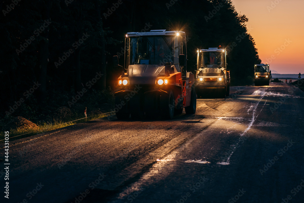 Obraz premium Road construction equipment in action. The road service repairs the highway.