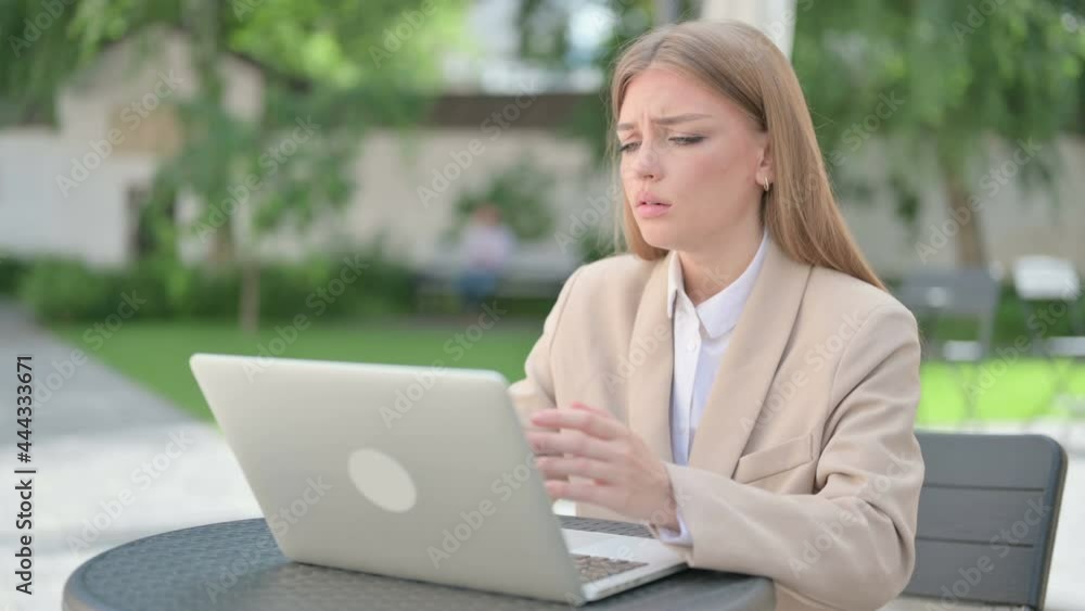 Young Businesswoman Reacting to Loss on Laptop in Outdoor Cafe Young Businesswoman Reacting to Loss on Laptop in Outdoor Cafe