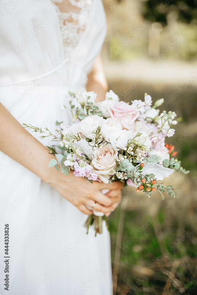 Bride holding wedding bouquet with white and pink flowers Bride holding wedding bouquet with white and pink flowers