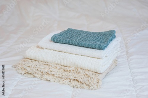 home textiles. A stack of towels lies on a white bed