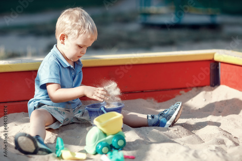 Foto Small boy playing with sand toys in a sandbox