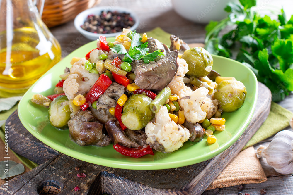 Stewed vegetables with chicken liver on wooden table. Healthy food. Stewed vegetables with chicken liver on wooden table. Healthy food.