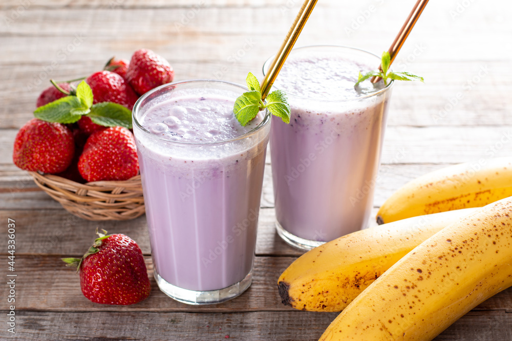 Food and drink, healthy dieting and nutrition, lifestyle, vegan, alkaline, vegetarian concept. Pink smoothie with banana and strawberry on wooden background. Food and drink, healthy dieting and nutrition, lifestyle, vegan, alkaline, vegetarian concept. Pink smoothie with banana and strawberry on wooden background.