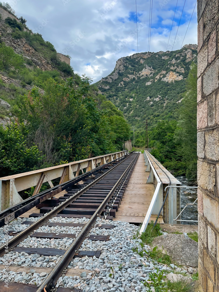 Bridge with railway track leading into the pyrenees mountains, Villefranche-de-Conflent, France Bridge with railway track leading into the pyrenees mountains, Villefranche-de-Conflent, France