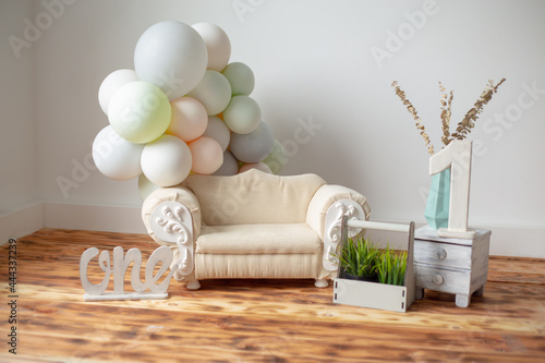 beautiful location for a children's photo shoot for one year. sofa, balls, number one on the wooden floor.