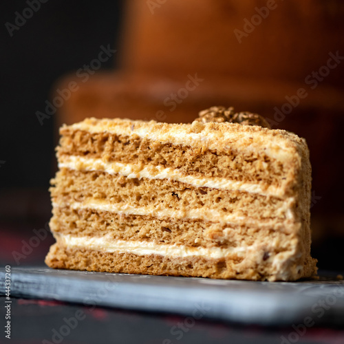 Piece of birthday cake on blurred background. Blank for greeting card or festive banner. Copy space for text. Close-up shot. Soft focus.
