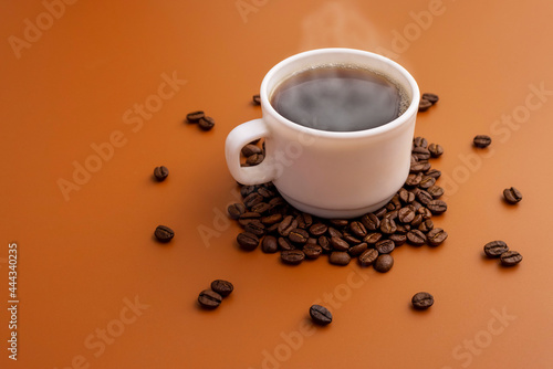 Coffee cup and roasted beans arranged as clock face on brown background. Coffee time concept. Coffee as a symbol of morning energy and vigor or evening refreshment