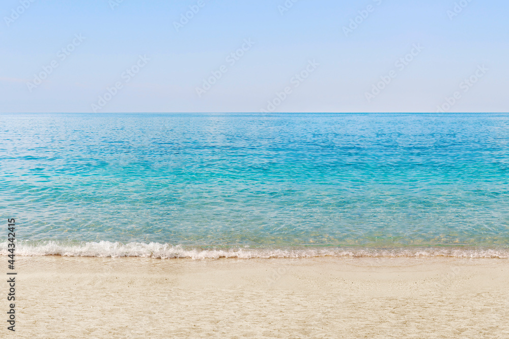 A beach with white sand, turquoise ocean water and blue clear sky. Summer holidays. The concept of a tourist holiday on a summer beach on the island. View of an empty beach. Calm sea. A beach with white sand, turquoise ocean water and blue clear sky. Summer holidays. The concept of a tourist holiday on a summer beach on the island. View of an empty beach. Calm sea.