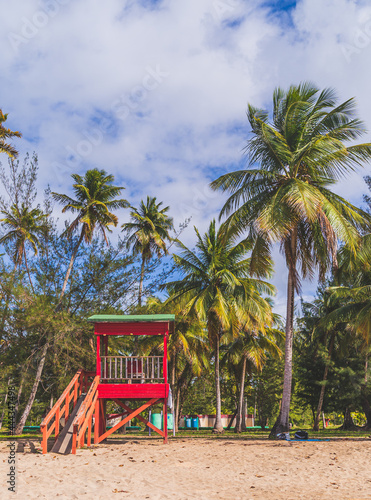 Red Life guard hut and palm trees on tropical beach. Luquillo Beach, Puerto Rico © RandomHartz