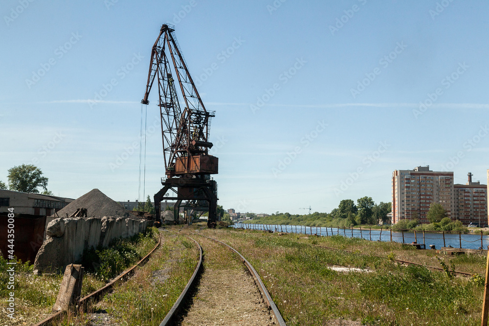 Industrial cranes in a small river port of a small town Industrial cranes in a small river port of a small town