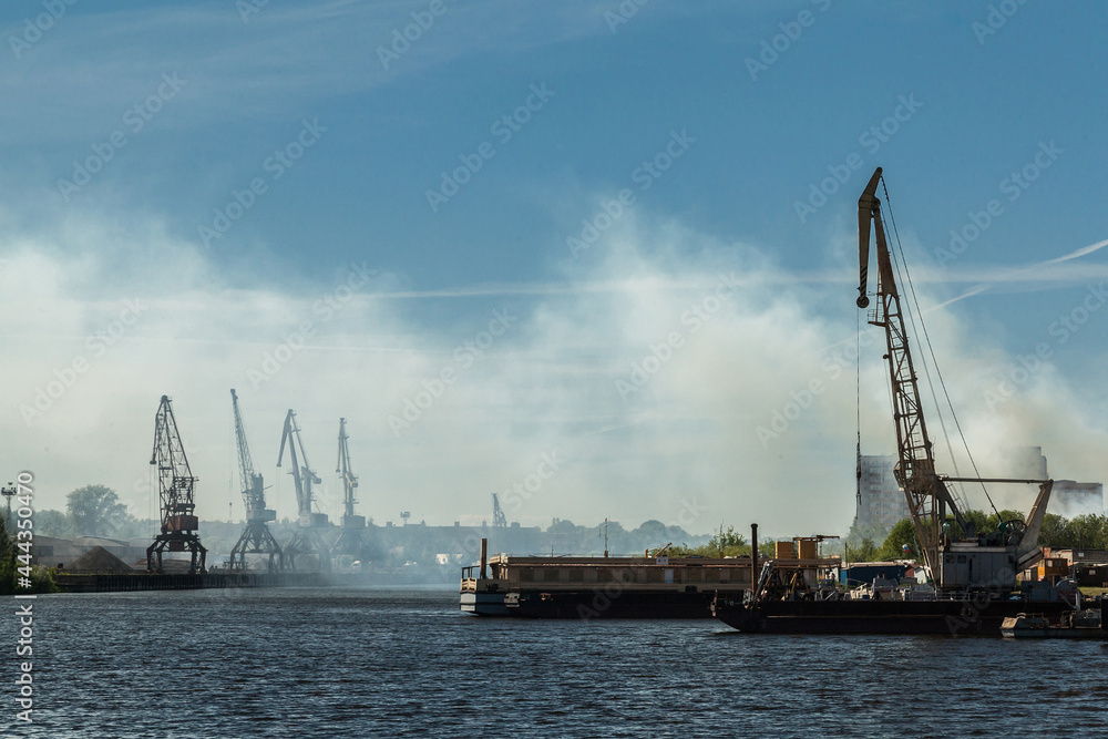 Small river port with industrial cranes
