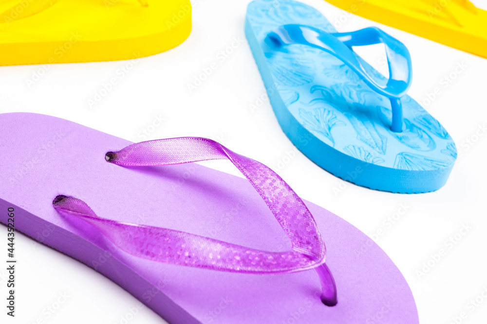 multi-colored rubber beach flip flops on a white background multi-colored rubber beach flip flops on a white background