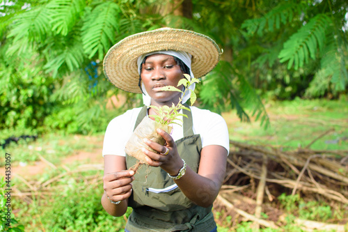 Fotografia, Obraz African female gardener, florist or horticulturist wearing an apron and a hat, h