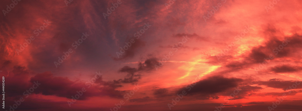 Fototapeta premium Horizontal panorama of a dramatic red black glowing cloudy sky at sunset. Sky texture. Abstract nature background