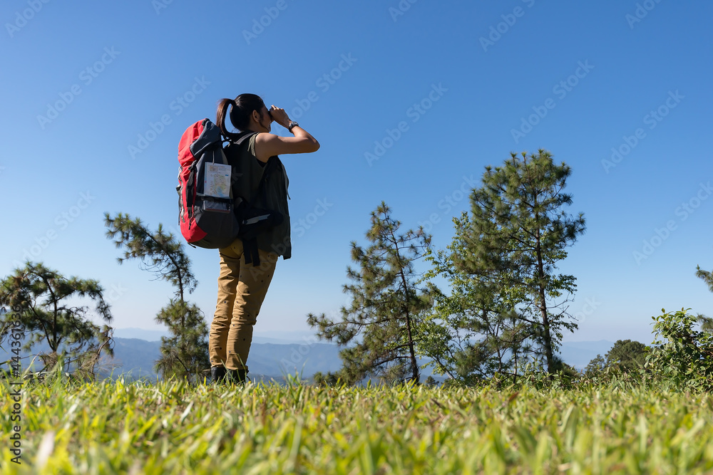 The traveler hipsters beautiful Asian girl are using binoculars looking for travel destination during a wild holiday amidst Sun evening.Travel Concept.. The traveler hipsters beautiful Asian girl are using binoculars looking for travel destination during a wild holiday amidst Sun evening.Travel Concept..
