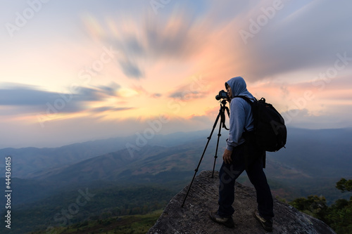 Professional photographer takes photos with mirror camera on peak of rock.Dreamy landscape