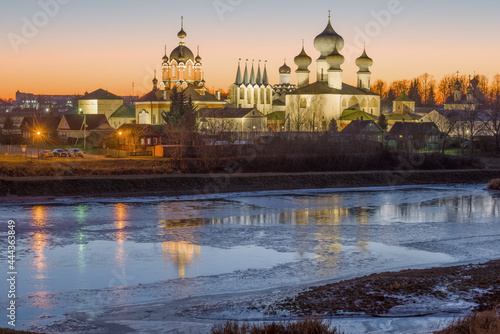 A view of the temples of the Tikhvin Theotokos Assumption Monastery from the side of the Tikhvinka River in the December sunset. Leningrad region, Russia