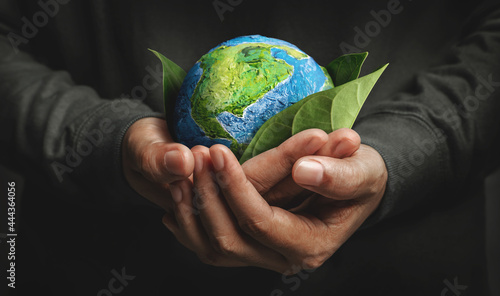 World Earth Day Concept. Green Energy, Renewable and Sustainable Resources. Environmental and Ecology Care. Hand Embracing Green Leaf and Handmade Globe