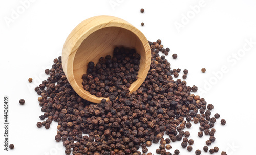 black pepper in a wooden bowl isolated on white background