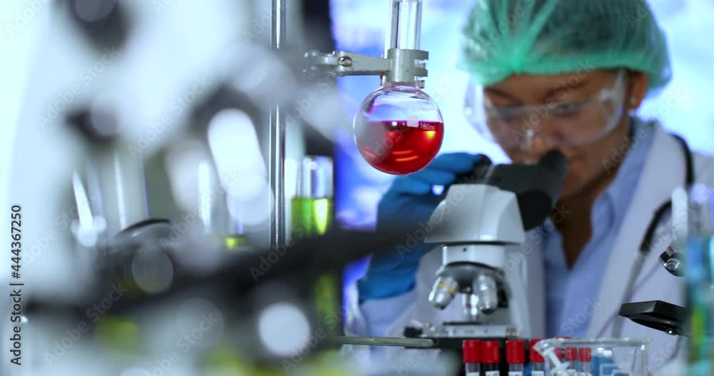 Pan shot of a working female asian scientist in the laboratory with multiple lab equipment and microscope. Healthcare technology and pharmaceutical research and development concept. Pan shot of a working female asian scientist in the laboratory with multiple lab equipment and microscope. Healthcare technology and pharmaceutical research and development concept.