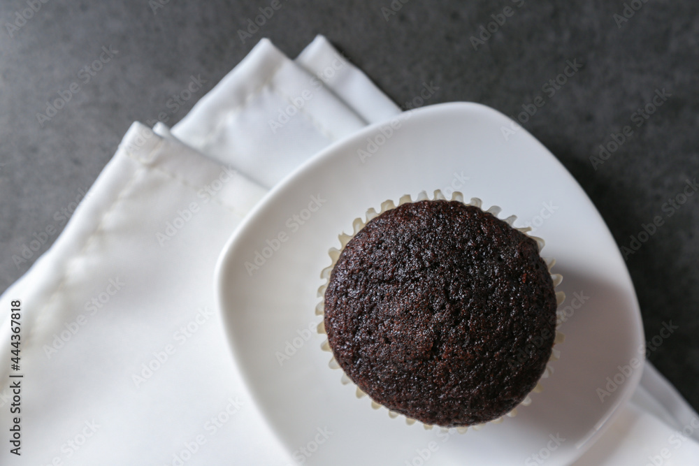 Delicious and fresh chocolate muffins on a gray ceramic table. Delicious and fresh chocolate muffins on a gray ceramic table.