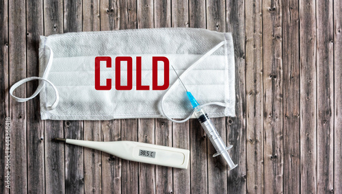 Cold season concept. The text is coldly written on a medical mask.