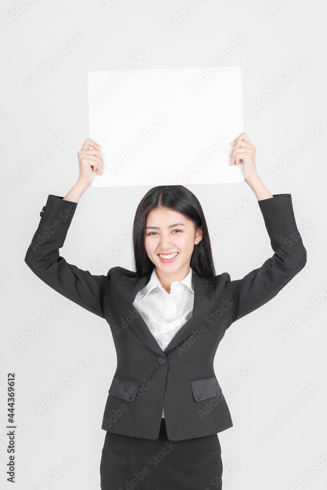 Portrait young working woman in black suit smiling and holding a blank space for advertising banner , space on white background, copy space Portrait young working woman in black suit smiling and holding a blank space for advertising banner , space on white background, copy space