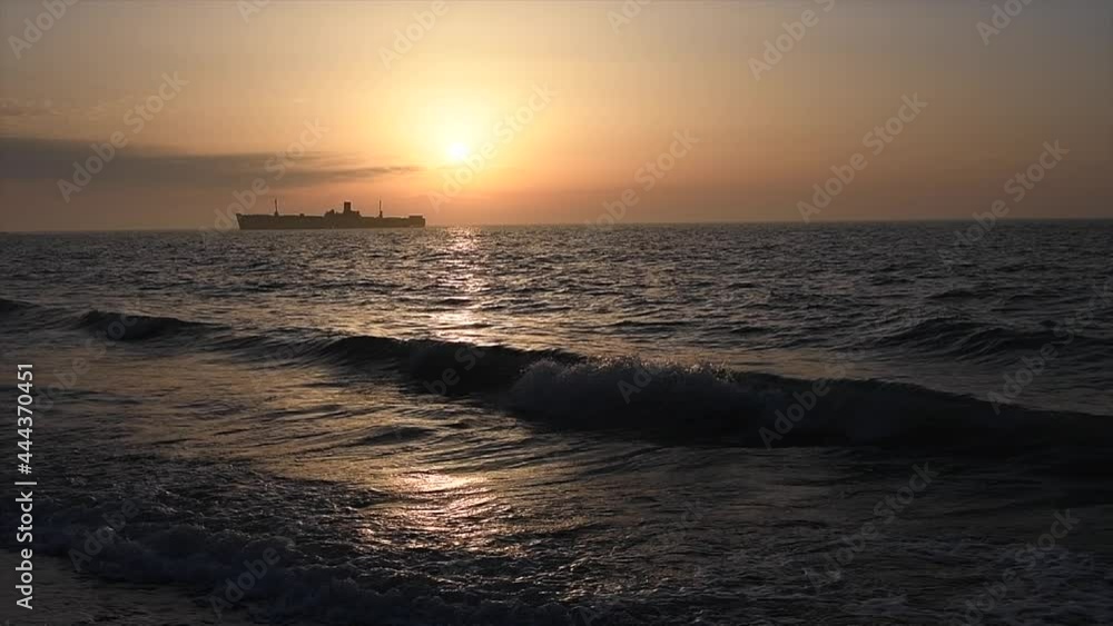Sunrise landscape over sea slow motion with orange sky waves and ship at horizon in summer Sunrise landscape over sea slow motion with orange sky waves and ship at horizon in summer