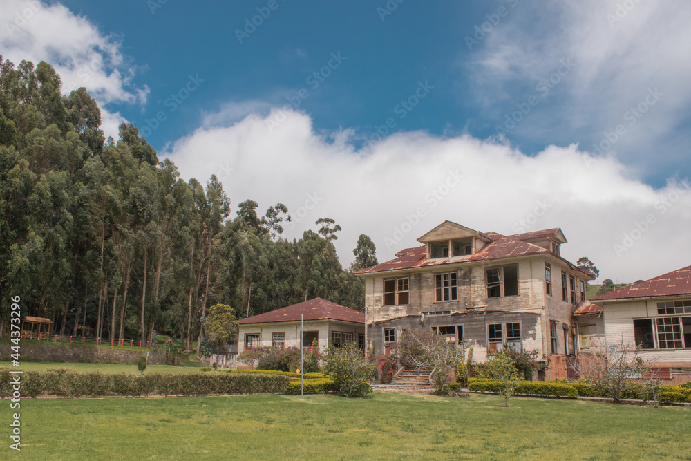 Horizontal shot of an abandoned house with a green landscape of the forest and gardens in Sanatorio Durán on a beautiful cold afternoon - Cartago - Costa Rica - Central America