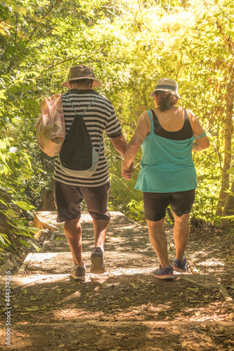 Senior adult tourists walking hand in hand along the path surrounded by dry tropical forest in the Rincon de La Vieja National Park Guanacaste Costa Rica Central America
