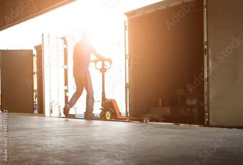 Warehouse Worker Unloading Package Boxes Out of The Inside Cargo Container. Truck Parked Loading at Dock Warehouse. Delivery Service. Shipping Warehouse Logistics. Freight Truck Transportation.	
 photo