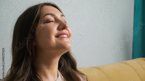Fotografija Happy woman enjoying the wind from the fan.