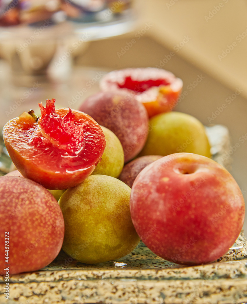 Red and yellow fresh plums on plate ready to eat Red and yellow fresh plums on plate ready to eat