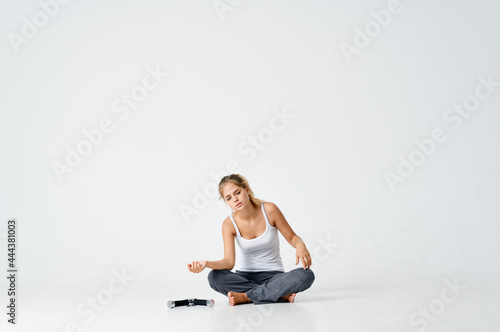 sportive woman sitting on the floor with dumbbells muscles training arms © SHOTPRIME STUDIO