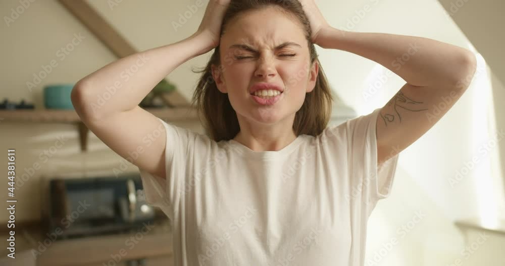 Close-up shooting of a beautiful brunette girl of Slavic appearance wearing a white T-shirt with loose hair, who looks angrily at the camera, grabs her head and shouts, Close-up shooting of a beautiful brunette girl of Slavic appearance wearing a white T-shirt with loose hair, who looks angrily at the camera, grabs her head and shouts,