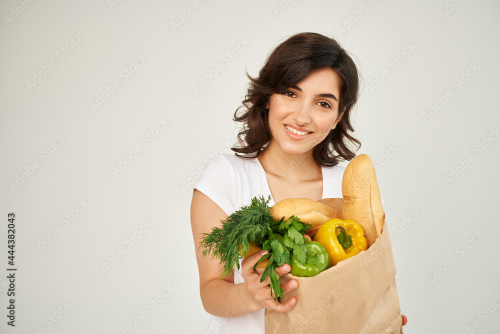 cheerful woman with a package of groceries supermarket light background cheerful woman with a package of groceries supermarket light background