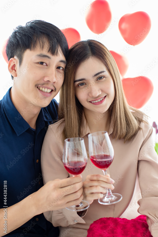Happy Asian couple proposing toast during date Happy Asian couple proposing toast during date
