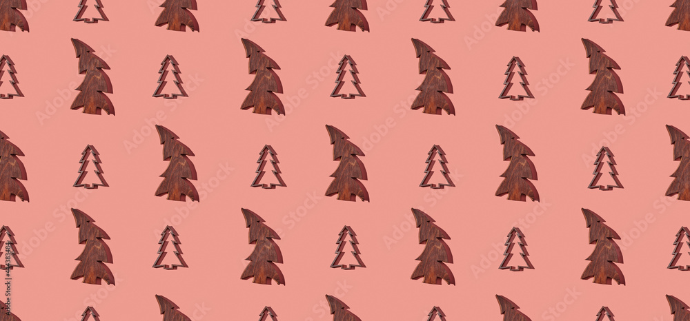 Fototapeta premium Pattern of wooden christmas trees on pink pastel background