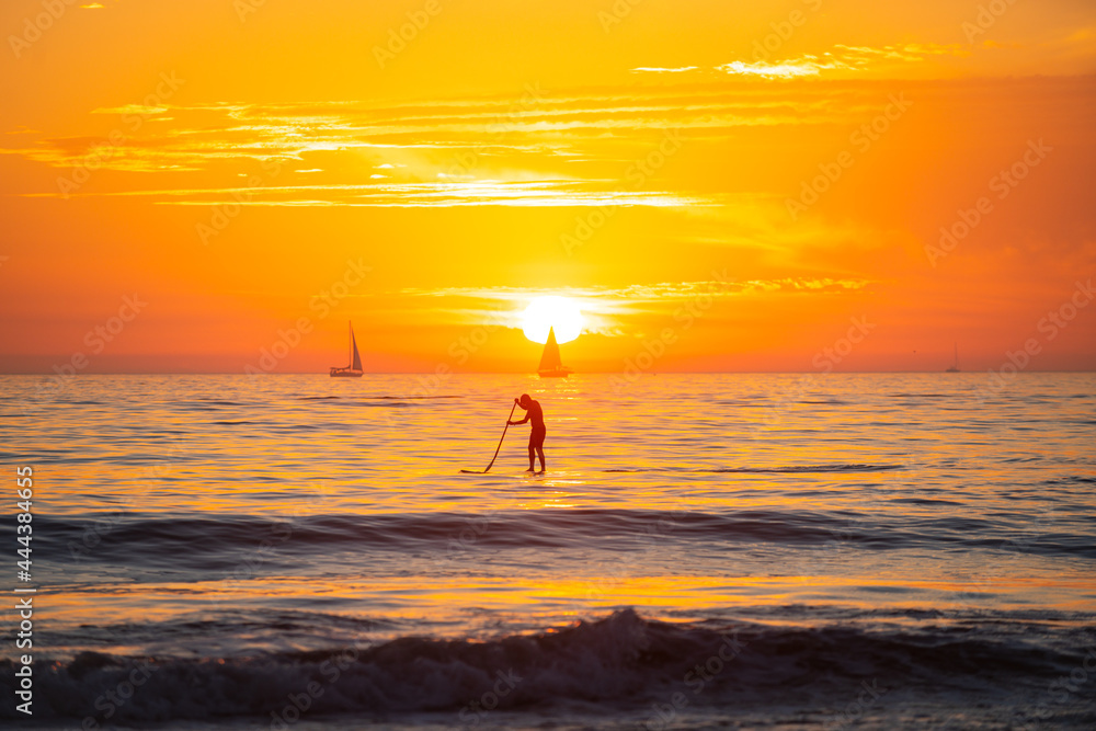 Paddle boarding. Sea beach with sunset sky abstract background. Copy space of summer vacation and travel concept.