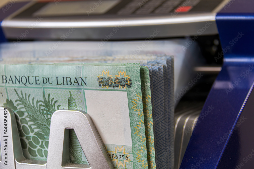 Fototapeta premium Lebanese Lira Currency being counted by a money counting machine