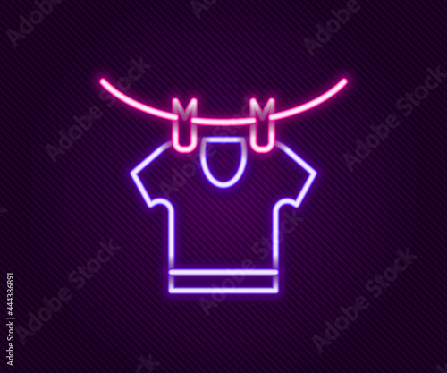 Glowing neon line Drying clothes icon isolated on black background. Clean shirt. Wash clothes on a rope with clothespins. Clothing care and tidiness. Colorful outline concept. Vector